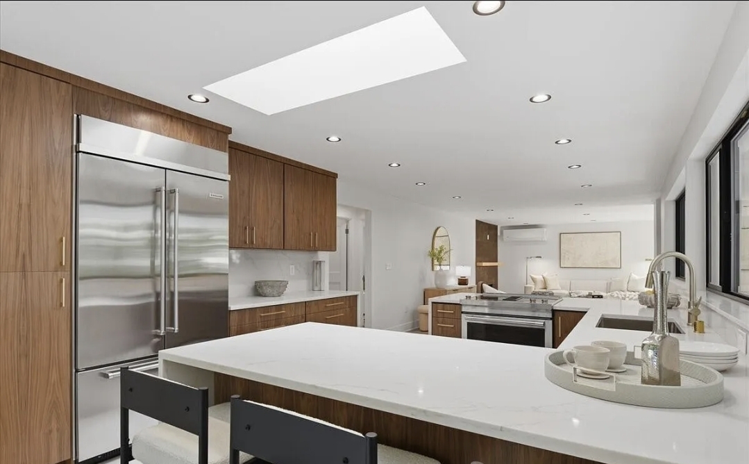 Renovated kitchen with walnut cabinetry and marble waterfall island